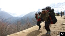 Nepalese porters carry heavy loads for climbers on their way to Everest Base Camp at Kyangjuma, Nepal in this April 7, 2015 photo.