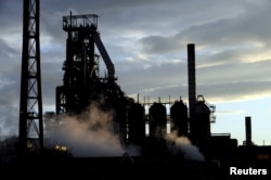 FILE - One of the blast furnaces of the Tata Steel plant is seen at sunset in Port Talbot, South Wales, May 31, 2013.