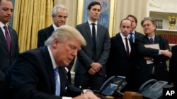 White House chief strategist Steve Bannon (far right) is among the top policy advisers present as President Donald Trump signs an executive order in the Oval Office, Monday, Jan. 23, 2017.