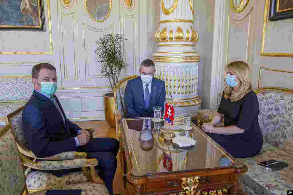 Slovakian President Zuzana Caputova, right, outgoing Prime Minister Peter Pellegrini, center, and his potential successor Igor Matovic wear face masks to protect against coronavirus, during a meeting at the Presidential Palace in Bratislava.