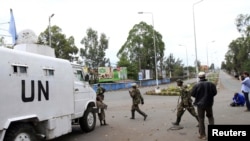 Des rebelles du M23 passent devant une patrouille de la Monuscop à Goma (20 nov. 2012)