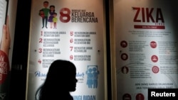 FILE - A woman passes a poster explaining about the Zika virus at the Ministry of Health in Jakarta, Indonesia, Sept. 2, 2016.