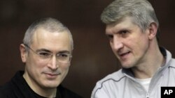 Mikhail Khodorkovsky (kiri) dan rekannya Platon Lebedev berbicara di pengadilan Moskow, Rusia (Foto: dok). Pengadilan Kota Moskow telah mengurangi hukuman bagi pemimpin oposisi dan mantan pengusaha minyak, Khodorkovsky, sehingga terbuka jalan baginya untuk bebas tahun 2014.