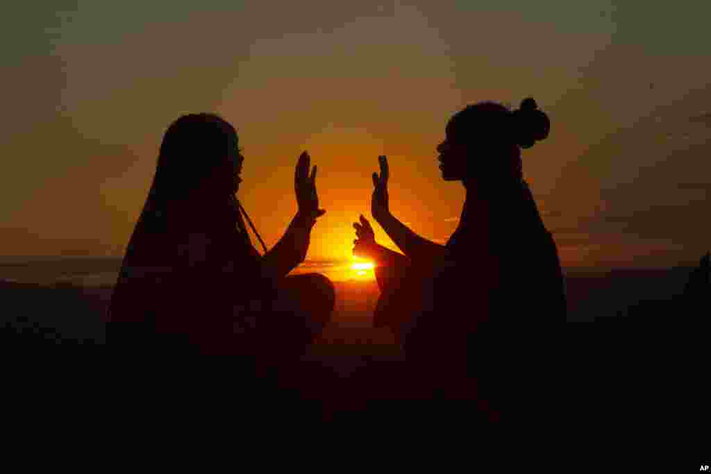 Girls have fun while playing on top of a hill at sunset on Africa Day in Harare, Zimbabwe.