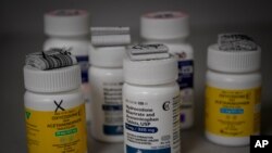 FILE - Bottles of several opioid based medication are seen at a pharmacy in Portsmouth, Ohio, June 21, 2017.