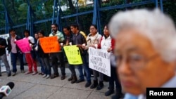 Migrants from Central America hold candles during a protest demanding a reform in U.S. immigration laws which regulate the illegal exodus of children into the U.S., and to provide protection for them, outside the U.S. embassy in Mexico City, August 9, 201