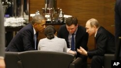 U.S. President Barack Obama, left, speaks with Russian President Vladimir Putin, right prior to the opening session of the G-20 summit in Antalya, Turkey, Nov. 15, 2015. 