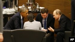 U.S. President Barack Obama, left, speaks with Russian President Vladimir Putin, right prior to the opening session of the G-20 summit in Antalya, Turkey, Nov. 15, 2015. 