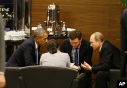 U.S. President Barack Obama, left, speaks with Russian President Vladimir Putin, right prior to the opening session of the G-20 summit in Antalya, Turkey, Nov. 15, 2015.