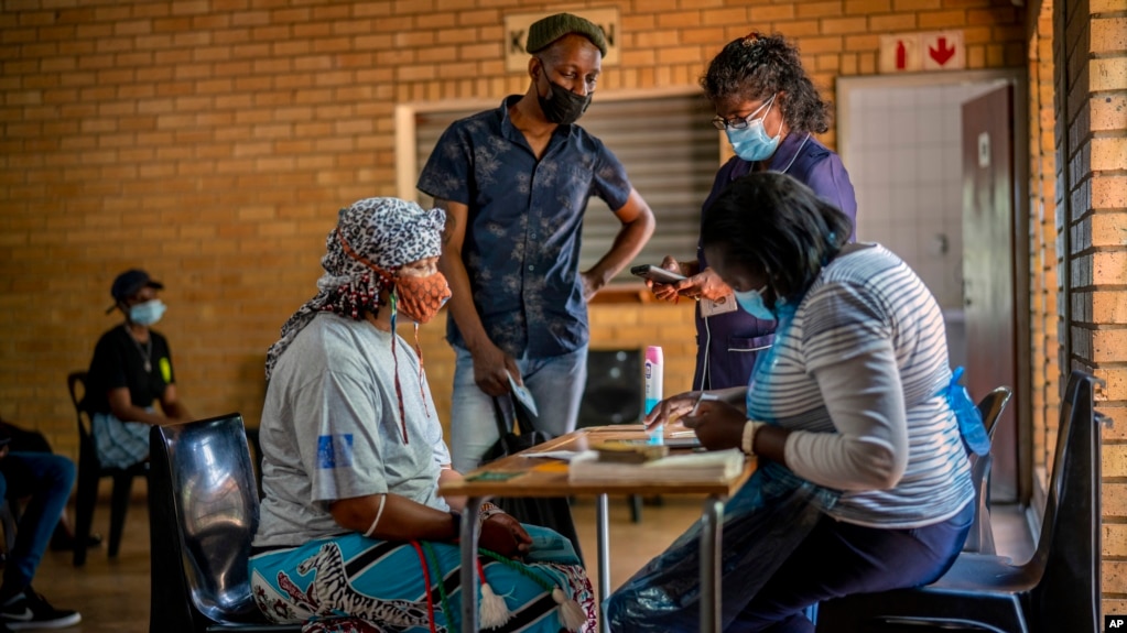 People are processed before receiving their jab against COVID-19 Friday Dec. 3, 2021 at the Orange Farm, South Africa, multipurpose center. (AP Photo/Jerome Delay)