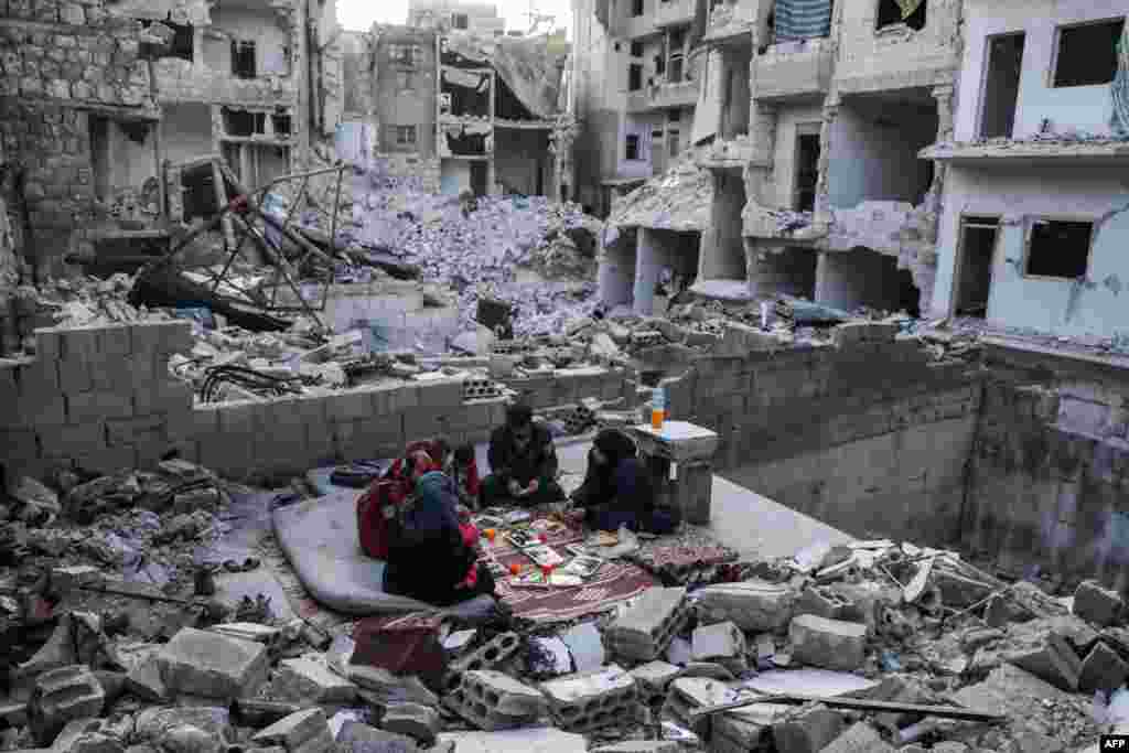 A displaced family of Tareq Abu Ziad, from the town of Ariha in the southern countryside of the Idlib province, Syria, break their fast for the sunset "iftar" meal, at their destroyed home during the Muslim holy month of Ramadan.
