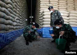 Soldiers check rice stocks at a warehouse in Ayutthaya province, north of Bangkok, Thailand, July 3, 2014.