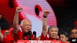 Malaysian Prime Minister and President of Malaysia's ruling party United Malays National Organization's (UMNO) Najib Razak (left) and Deputy Prime Minister Ahmad Zahid Hamidi chant a slogan during a celebration of party's 71st anniversary in Kuala Lumpur,