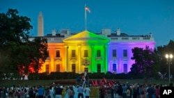 People gather in Lafayette Park to see the White House illuminated with rainbow colors in commemoration of the Supreme Court's ruling to legalize same-sex marriage in Washington, June 26, 2015.