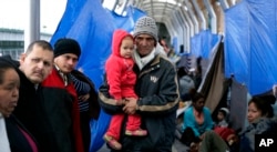 FILE - Families hoping to seek asylum in the United States wait on the bridge connecting Reynosa, Mexico, to Hidalgo, Texas, March 15, 2019.