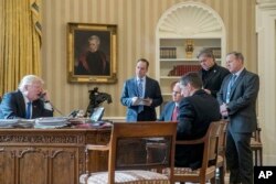 President Donald Trump, accompanied by from second from left, Chief of Staff Reince Priebus, Vice President Mike Pence, National Security Adviser Michael Flynn, Senior Advisor Steve Bannon, and White House press secretary Sean Spicer.