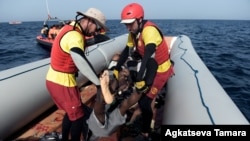 Les membres de Proactiva Open Arms portent le cadavre d'un migrant après une opération de sauvetage au large des côtes libyennes le 4 octobre 2016.