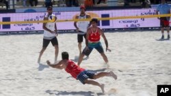In this picture made available by the Tasnim News Agency, an unidentified Iranian volleyball player defends a ball against his Turkish competitors during the International Beach Volleyball Championships at Iran's Kish Island, Feb. 15, 2016.