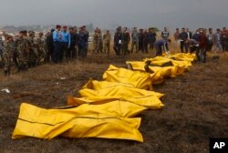 Nepalese rescuers attend to bodies of victims after a passenger plane from Bangladesh crashed at the airport in Kathmandu, Nepal, March 12, 2018.