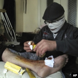 An injured man gets treated in a Damascus neighborhood, Syria, Tuesday, April 3, 2012.