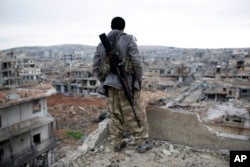 FILE - A Syrian Kurdish sniper looks at the rubble in the Syrian city of Kobani.