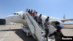 Daallo Airlines staff usher in passengers from Jeddah after their airline, Daallo Airlines operated by Air Mediterranee, arrived at the Aden Abdule International Airport in Somalia's capital Mogadishu, February 17, 2015.