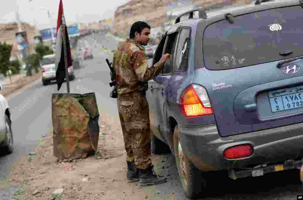 A Yemeni soldier inspects cars on a street leading to the U.S. embassy in Sanaa, August 4, 2013.