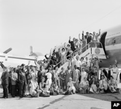 FILE - The first Peace Corps Volunteers to leave for overseas duty wave from the ramp of their plane at National Airport, Washington, D.C., Aug. 29, 1961, en route to teaching assignments in Ghana. (AP Photo)