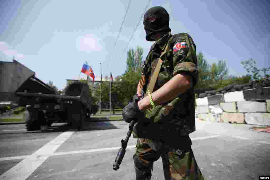 Seorang anggota kelompok bersenjata pro-Rusia yang baru dibentuk bernama Tentara Ortodoks Rusia menjaga barikade dekat bandara Donetsk, Ukraina, 29 Mei 2014.