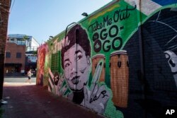 A mural decorates a building behind a Metro PCS store, May 25, 2019 in the Shaw neighborhood of Washington.