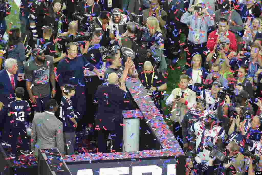 Patriots quarterback Tom Brady, center, holds up Vince Lombardi trophy after defeating the Atlanta Falcons in Superbowl 51 in Houston, Texas, Feb. 5, 2016. (Photo: B. Allen / VOA) 