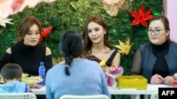 This photo taken on December 2, 2018 shows transgender make-up artist Solongo Batsukh (C) chatting at a salon in Ulaanbaatar, the capital of Mongolia.