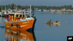 FILE - Sri Lankan fishermen stand on a fishing vessel as it leaves a fishery harbor in Negombo, Negombo, outskirts of Colombo, Sri Lanka.