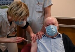 Alain, 92 tahun, menerima dosis pertama vaksin Covid-19 buatan Pfizer-BioNTech di rumah lansia Champmaillot di Dijon, Perancis tengah, Minggu, 27 Desember 2020. (Foto: AP)