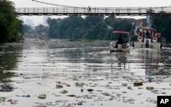 FILE - The Government's Pasig River Rehabilitation Commission and environmentalists from Greenpeace survey the polluted Pasig River to track plastic waste to draw attention to the hazards of plastics and waste which clog rivers and tributaries in San Juan