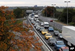 FILE - Czech taxis drive slowly blocking a major road to Prague's international airport to protest Uber and other alternative services in Prague, Czech Republic, Oct. 2, 2017.