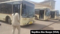 Sophie Diouck avance pour monter dans un bus de la société Dakar Dem Dikk, à Dakar, Sénégal, 25 février 2017. (VOA/ Seydina Aba Gueye)