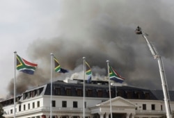 Smoke rises from the Parliament in Cape Town, South Africa, Jan 3, 2022 after the fire re-ignited late afternoon. Firefighters are again on the scene after a major blaze tore through the precinct a day earlier.