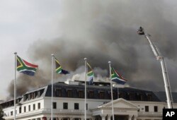 Smoke rises from the Parliament in Cape Town, South Africa, Jan 3, 2022 after the fire re-ignited late afternoon. Firefighters are again on the scene after a major blaze tore through the precinct a day earlier.