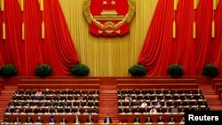 China's President Xi Jinping and other delegates listen as China's Premier Li Keqiang (not pictured) delivers a government work report during the opening session of the National People's Congress (NPC) at the Great Hall of the People in Beijing, China, Ma