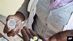 Nolitha Tsilana, a MSF nurse, delivers TB pills to a patient at Lizo Nobanda TB Care Centre in Khayelitsha township, Cape Town. 