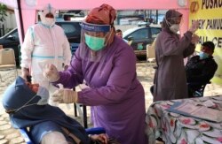 Petugas kesehatan melakukan tes usap kepada warga di tengah lonjakan kasus COVID-19 (foto: dok).