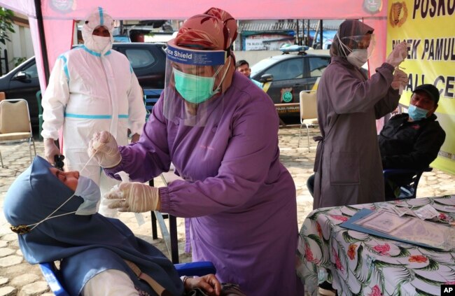 Petugas kesehatan melakukan tes usap kepada warga di tengah lonjakan kasus COVID-19 (foto: dok).
