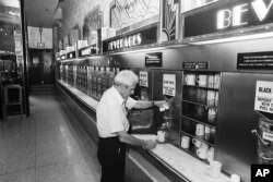Seorang pelanggan membeli secangkir kopi di satu-satunya restoran Horn & Hardart Automat yang masih bertahan di tengah kota Manhattan, New York City, 8 Juni 1987. (AP)