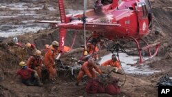 Firefighters prepare a body to be lifted away by a helicopter, after pulling the dead person from the mud days after a dam collapse in Brumadinho, Brazil, Jan. 28, 2019.