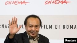 Cambodian director Rithy Panh waves as he poses during a photo call, Oct. 24, 2008 (File)