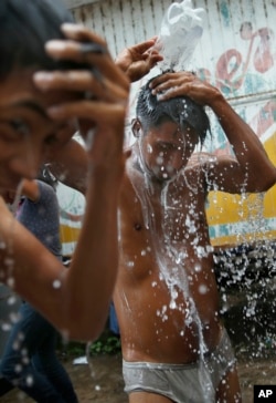 Migrantes centroamericanos, parte de la caravana que espera llegar a EE.UU., toman un baño en Isla, estado de Veracruz, México, sábado 3 de noviembre de 2018. (Foto AP / Marco Ugarte)