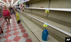 Shoppers pass empty shelves along the bottled water aisle in a Houston grocery store as Hurricane Harvey intensifies in the Gulf of Mexico, Aug. 24, 2017.