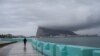 A pedestrian walks along the seafront in front of the Rock of Gibraltar as seen from La Linea de la Concepcion, Spain, Nov.22, 2018. 