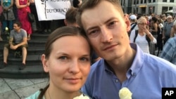 FILE - Ukrainian activist Lyudmyla Kozlovska (L), and her husband Bartosz Kramek are seen during an anti-government protest in Warsaw, Poland, Aug. 10, 2017.